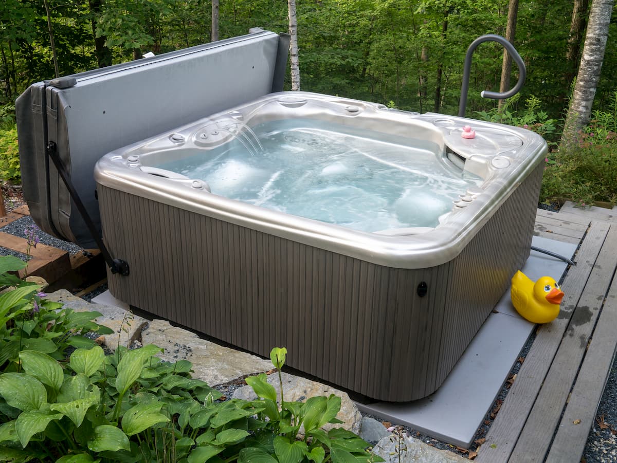 Hot tub spa in a wooded backyard and garden - How Much Does a Hot Tub Cost to Run