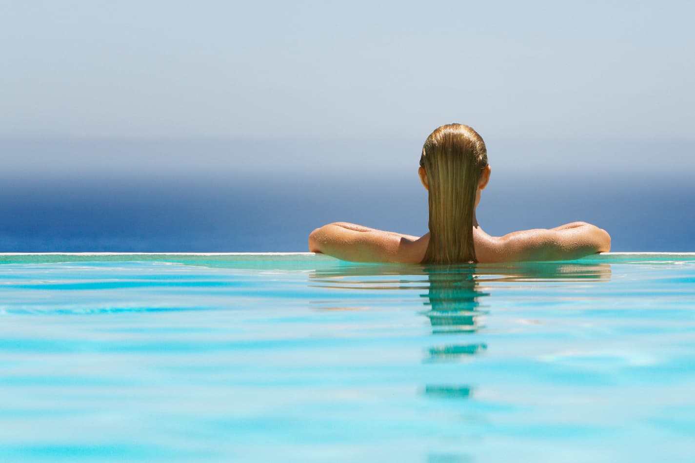 Woman at the edge of an infinite pool