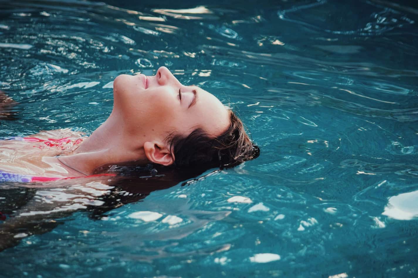 woman layed back and floating in a pool